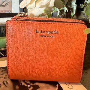 EUC orange Kate Spade small bifold wallet with zip around coin pocket.
